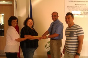 Mr. Agius, (Head of the Resource Centre) and Mr. Nicholas Camilleri (Resource Centre's Council representative) present a cheque  to Ms. Remona Cuschieri (House Mother) & Ms. Marvic Deguara (carer) 